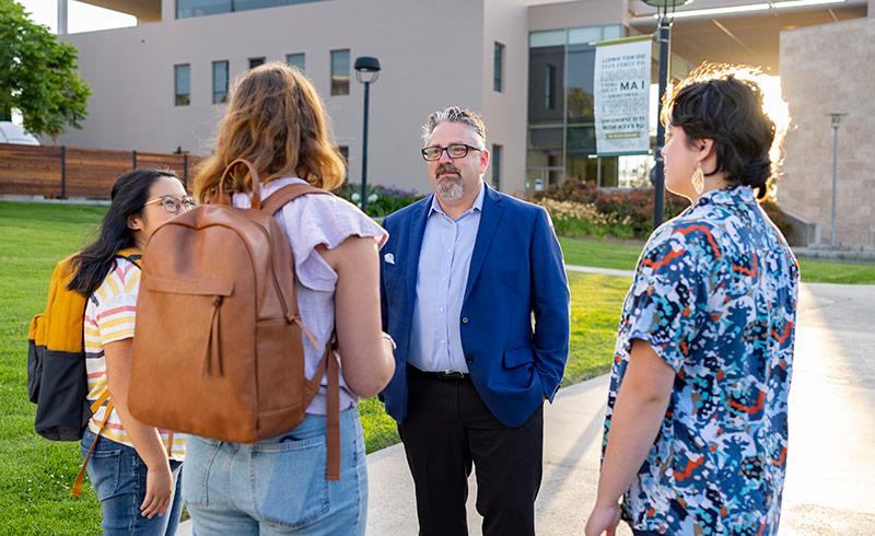 President Thomas talking with three Concordia students